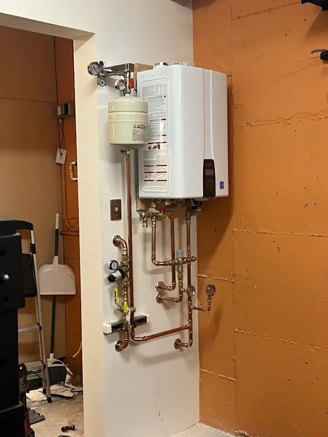 Plumbing technician inspecting water heater connections in Forest Park